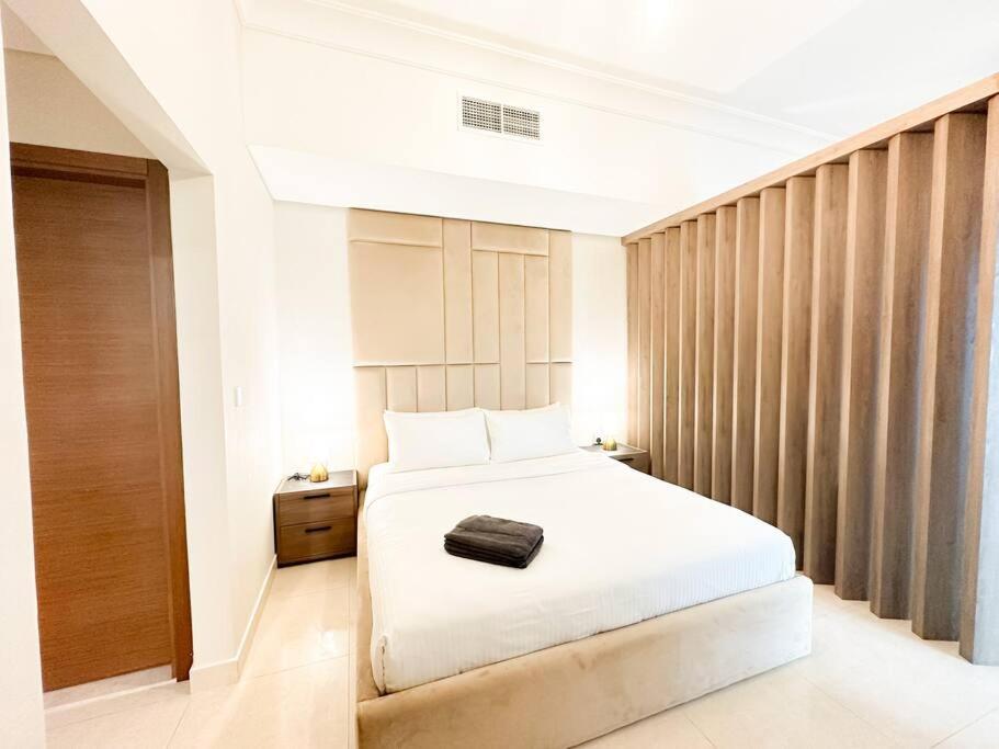 a bedroom with a white bed and a wooden wall at On-The-Go Golf 202B3 in Abu Dhabi