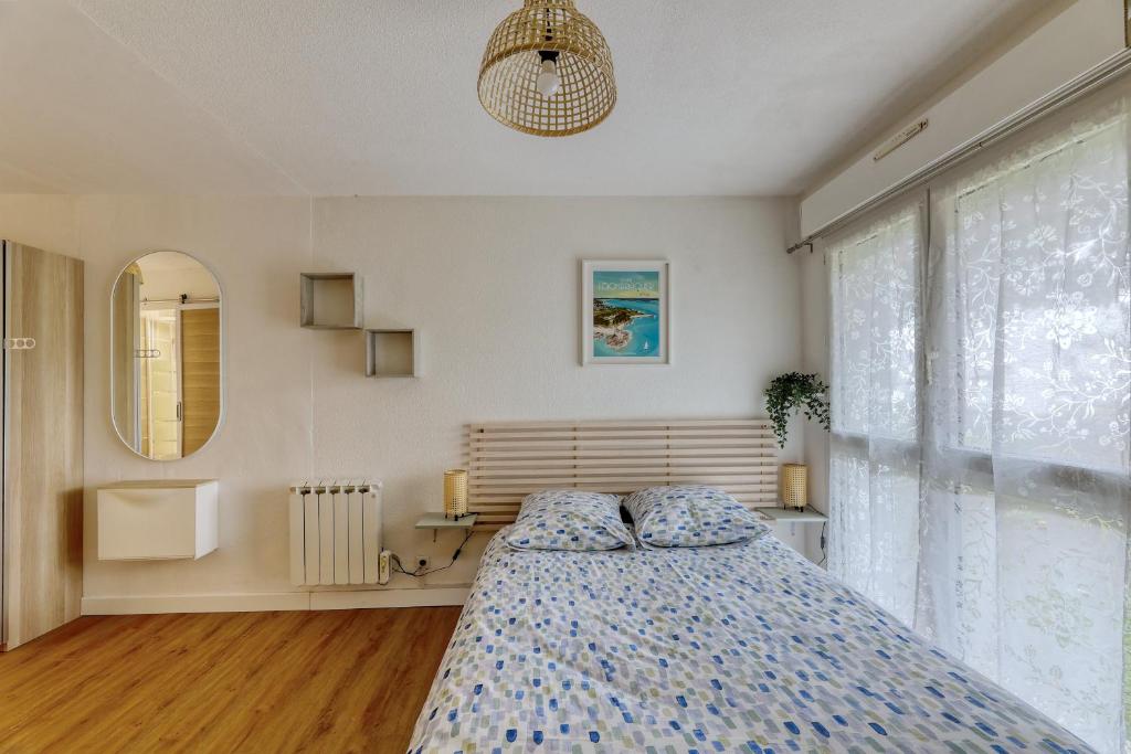 a bedroom with a bed and a large window at Charmant studio à 5 minutes de la mer à pied in Saint-Nazaire