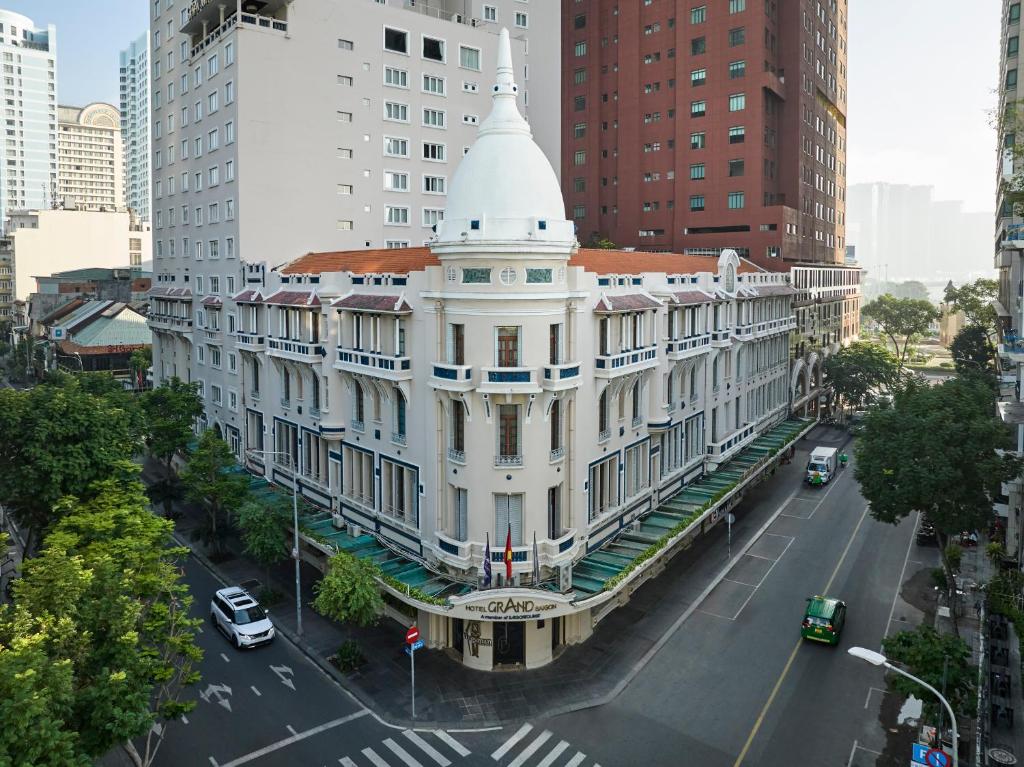 duży biały budynek z białą wieżą w mieście w obiekcie Hotel Grand Saigon w Ho Chi Minh