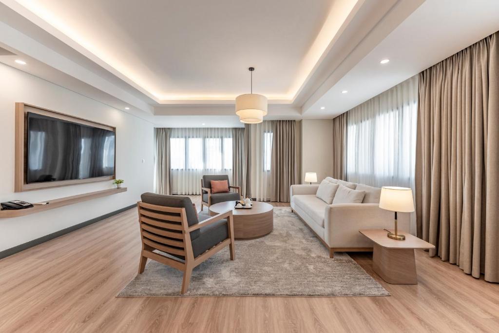 a living room with a couch and a tv at Garden View Court Suites Ho Chi Minh City in Ho Chi Minh City