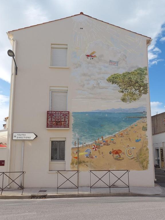 a mural of a beach on the side of a building at Au Tromp l'oeil Studio ou T2 in Sainte-Marie-la-Mer