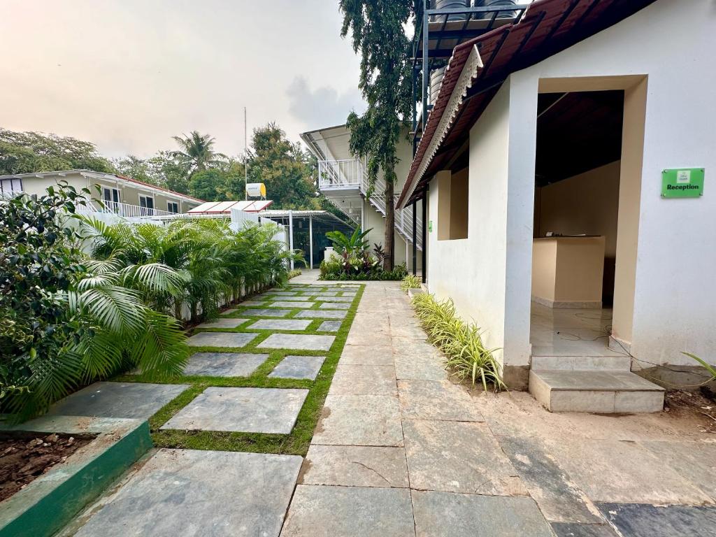 una pasarela fuera de una casa con plantas en Coco Hostel Goa, en Palolem