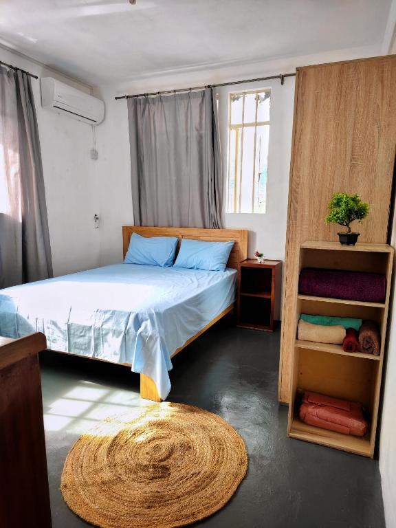 a bedroom with a bed and a book shelf at Port Louis Centre penthouse in Port Louis