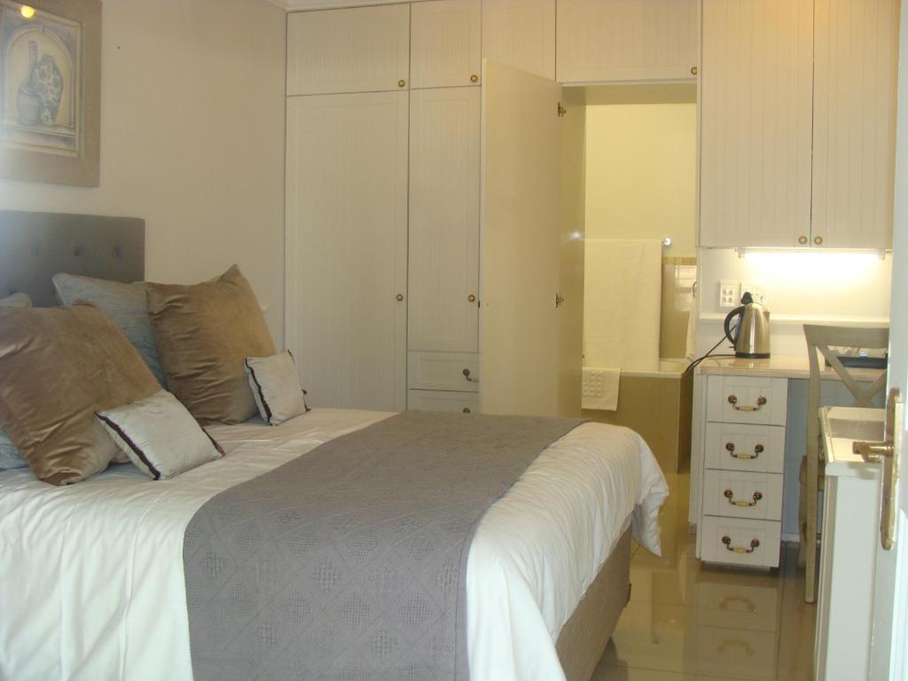 Lonehill - Standard 2 Guest Studio Suite 2 في Sandton: غرفة نوم بسرير كبير ومطبخ