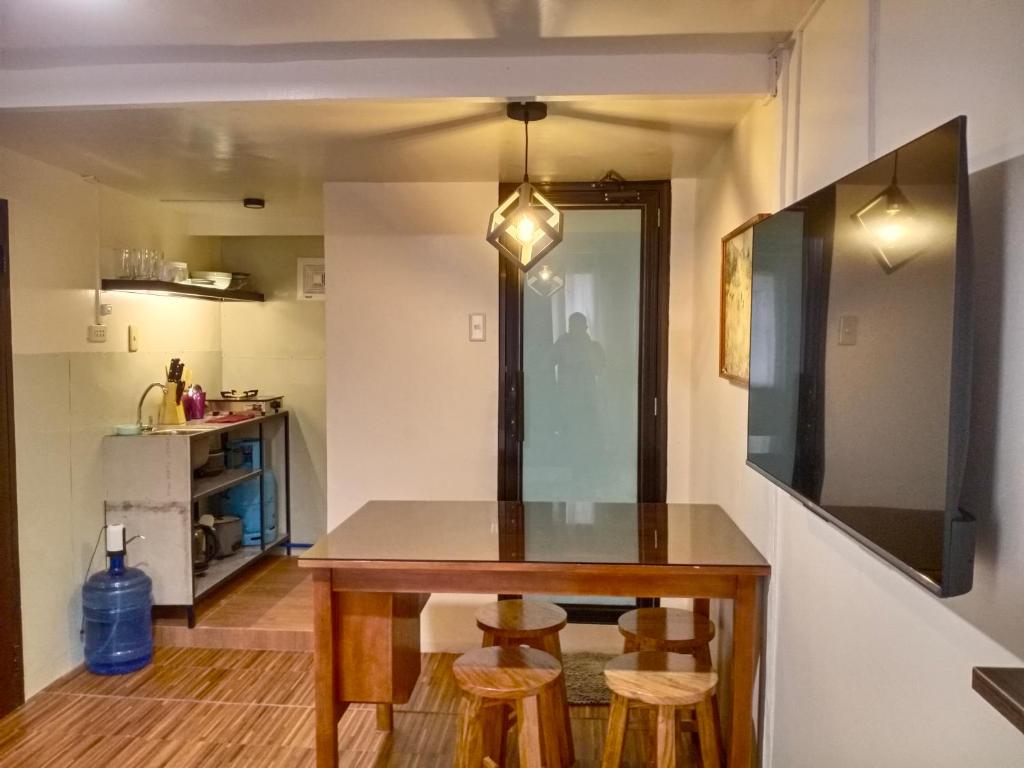 a small kitchen with a table and stools at Z&J Transient Pad in Butuan