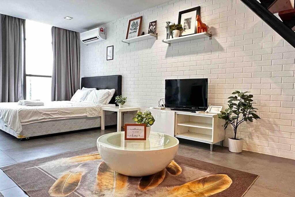 um quarto com uma parede de tijolos brancos e uma cama em Free Parking, 6pax Family Duplex Empire Damansara em Petaling Jaya
