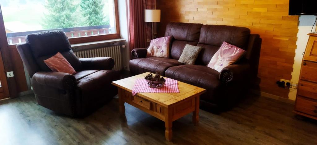 a living room with a leather couch and a coffee table at Ferienwohnung Alpenfreude in Missen-Wilhams