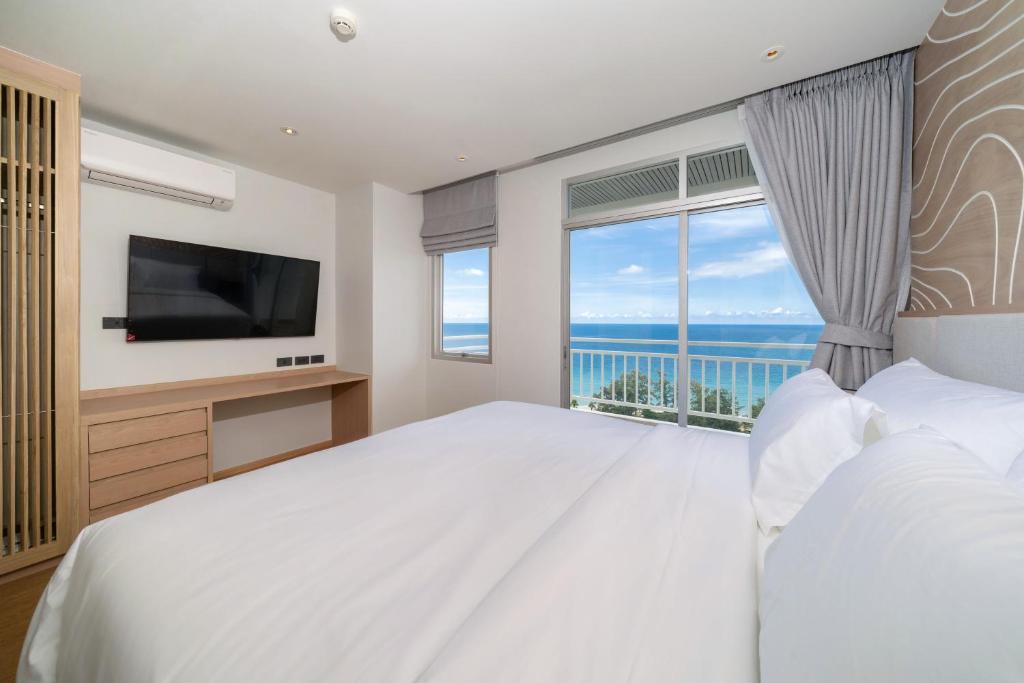 a bedroom with a large bed and a large window at Chic Design & Full Seaview 2BR Karon Condo 16C, near Beach in Karon Beach