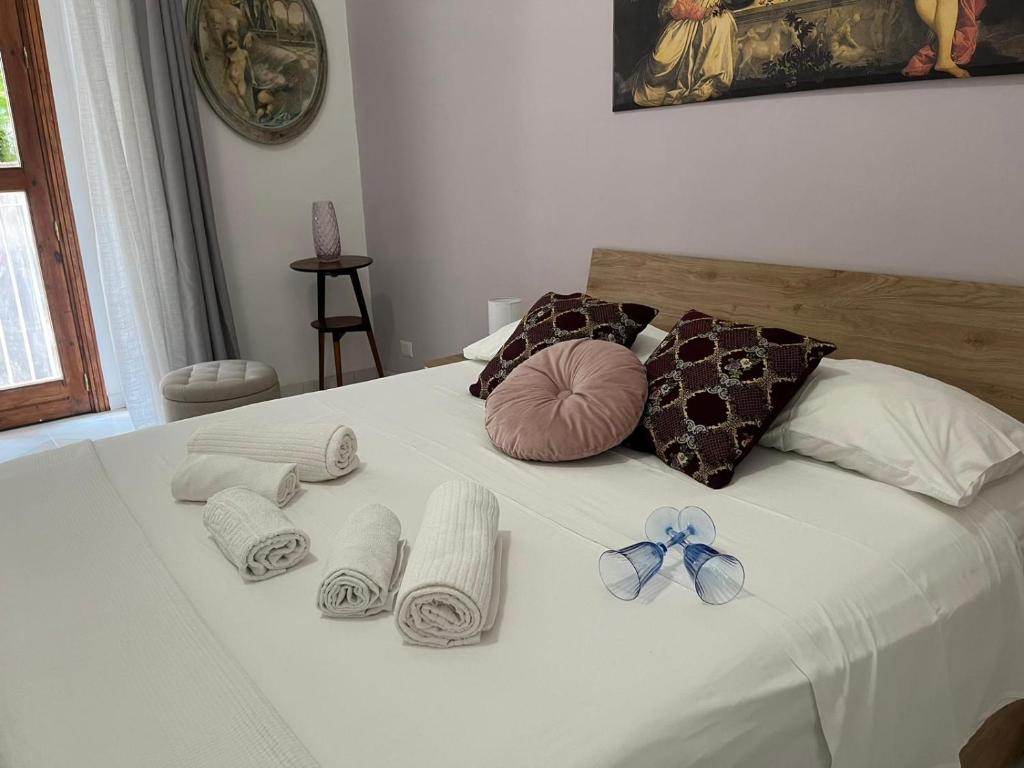Una cama blanca con toallas y arcos. en GL Golden City Apartments, en Catania