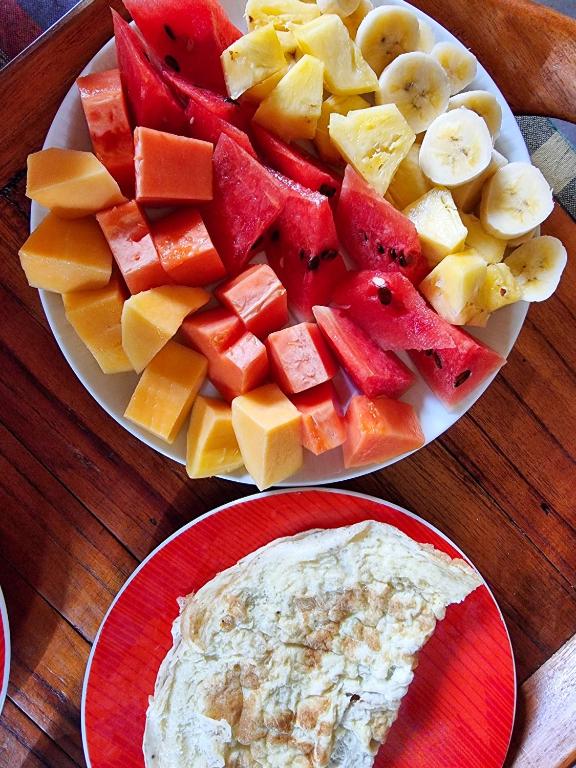 a plate of fruit and a plate of dip on a table at Hilltop Guest House in Ella