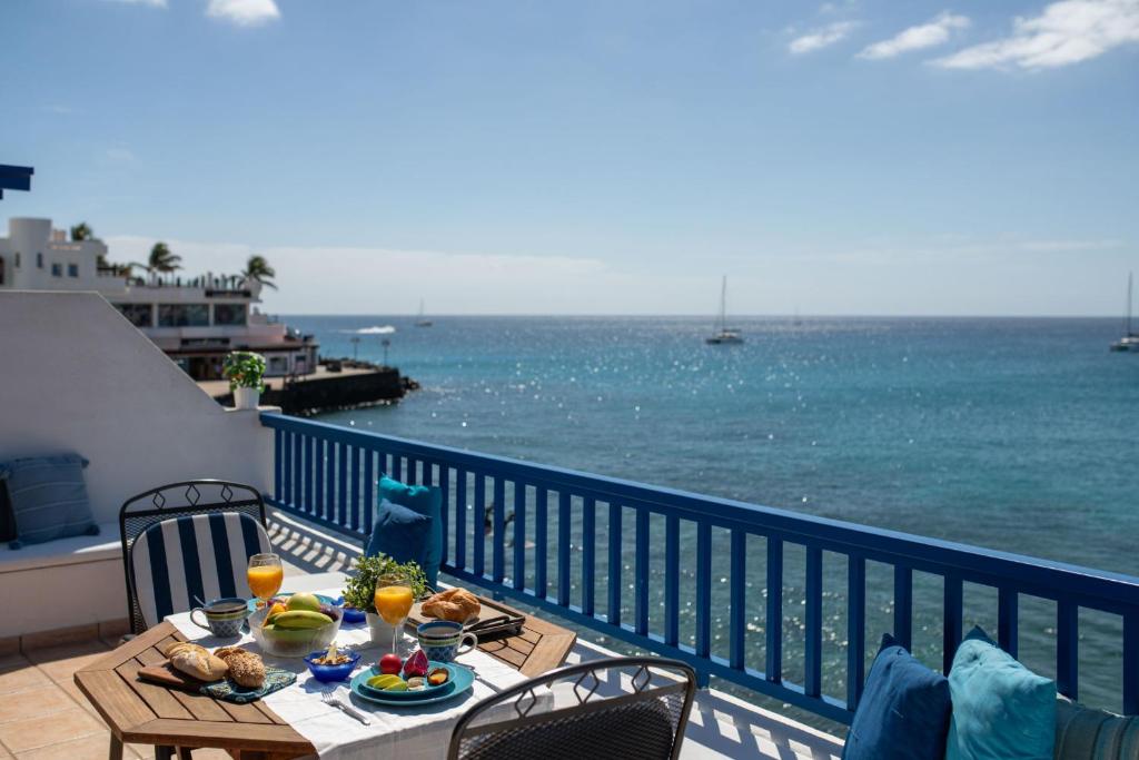a table on a balcony with a view of the ocean at Sweet Blue in Playa Blanca