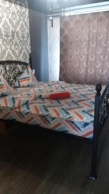 un letto con una trapunta sopra di Квартира 3-х комнатная a Temirtaū