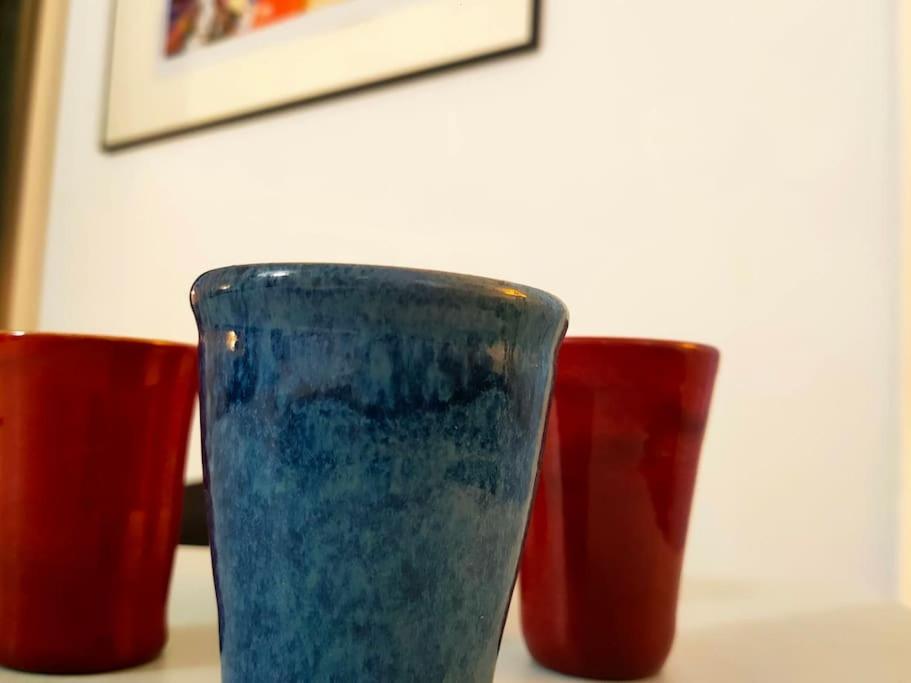 trois tasses rouges et bleues assises sur une table dans l'établissement Appartement les Abbesses, à Paris