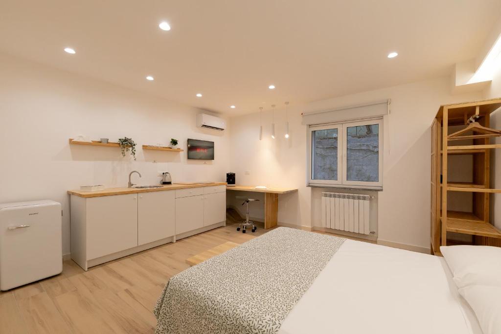 1 dormitorio con 1 cama y cocina con fregadero en Maison Nona, en Torre del Greco