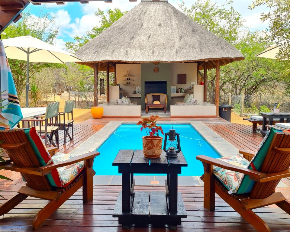 a gazebo with chairs and a table next to a pool at The Dreamcatcher Lodge in Hoedspruit
