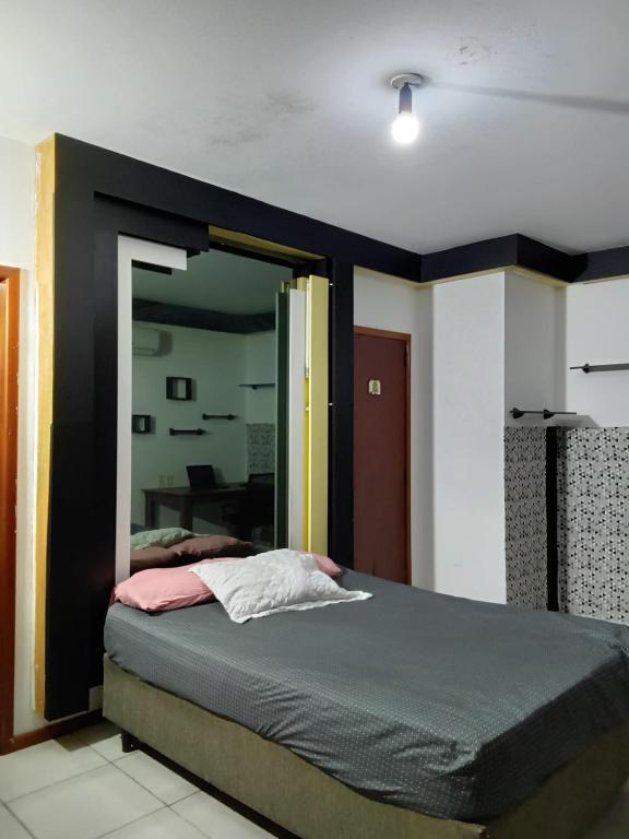 um quarto com uma cama grande e um espelho em republica madagascar em Florianópolis