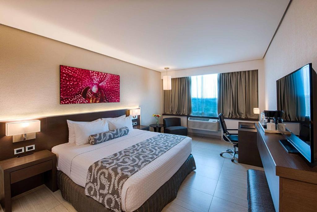 a hotel room with a bed and a flat screen tv at Crowne Plaza Airport by IHG in Tocumen