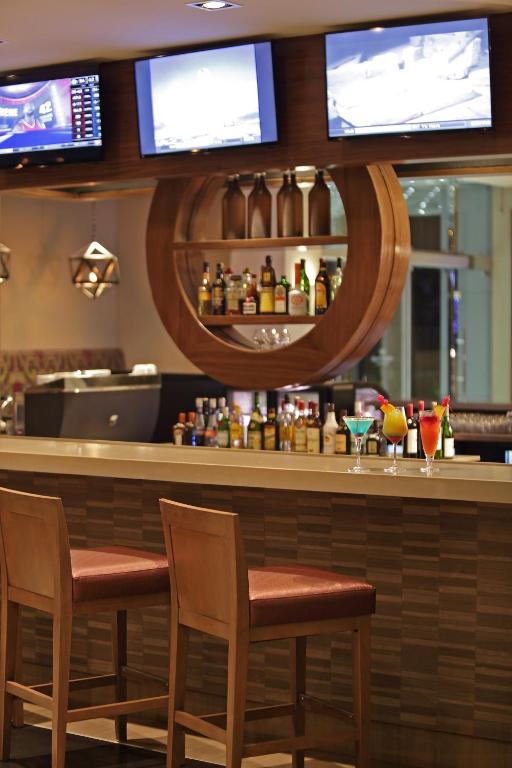 a bar in a restaurant with two chairs and a mirror at Crowne Plaza Airport by IHG in Tocumen