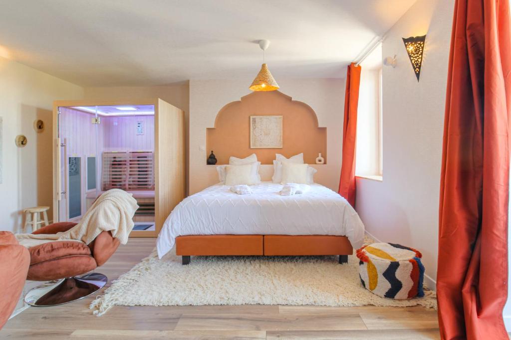 - une chambre avec un lit à baldaquin orange dans l'établissement L' Oriental Suite de Luxe, à Serrières