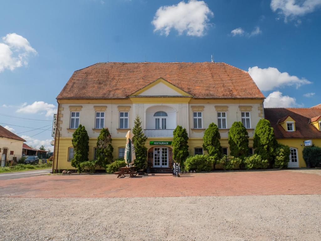 a large yellow house with a tile roof at Hotel Club in Vranovská Ves