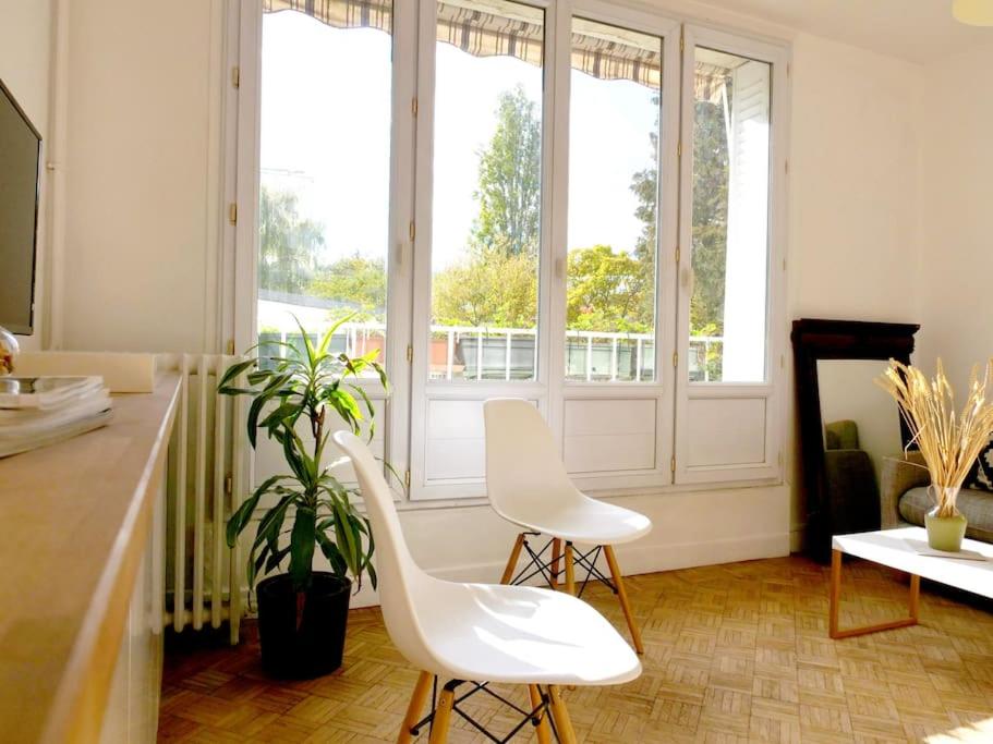 duas cadeiras brancas num quarto com janelas em Appartement de designer, Cosy Lumineux, 3 chambres em Le Kremlin-Bicêtre