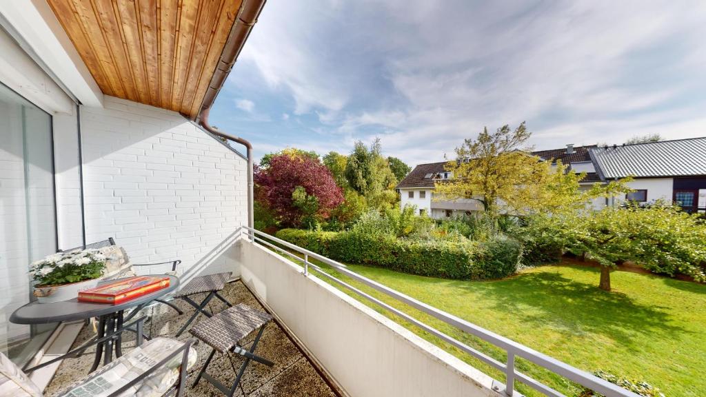 d'un balcon avec une table, des chaises et une cour. dans l'établissement NeuKlosterhof App. 16, à Pelzerhaken