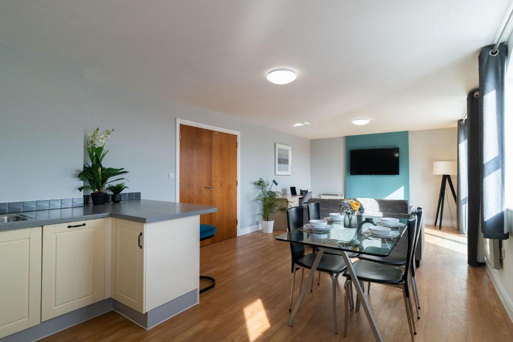 cocina y sala de estar con mesa y sillas en Cotels - The Millhouse NEWLY REFURBISHED MODERN APARTMENTS WITH ULTRAFAST BROADBAND, FREE PARKING & A WORK DESK en Derby