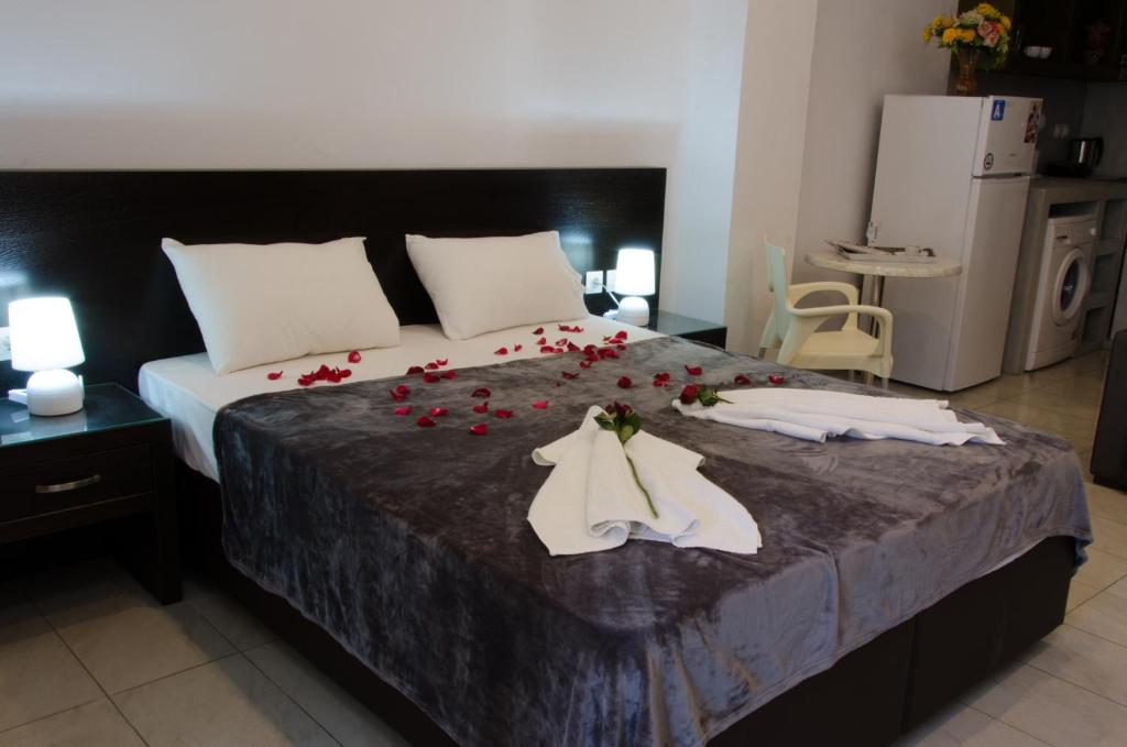 una camera da letto con un letto con rose rosse di Polykratis Rooms a Città di Skiathos