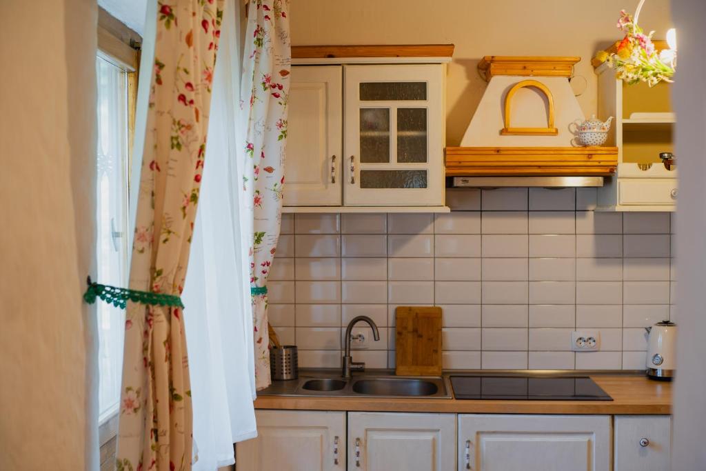 una cocina con armarios blancos y fregadero en La sat en Bertea