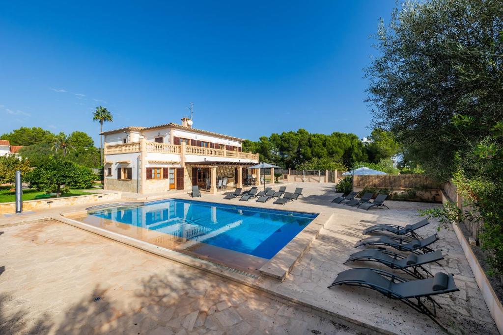 una casa con piscina delante de una casa en Villa Can Tosam Meiga, en Calas de Mallorca
