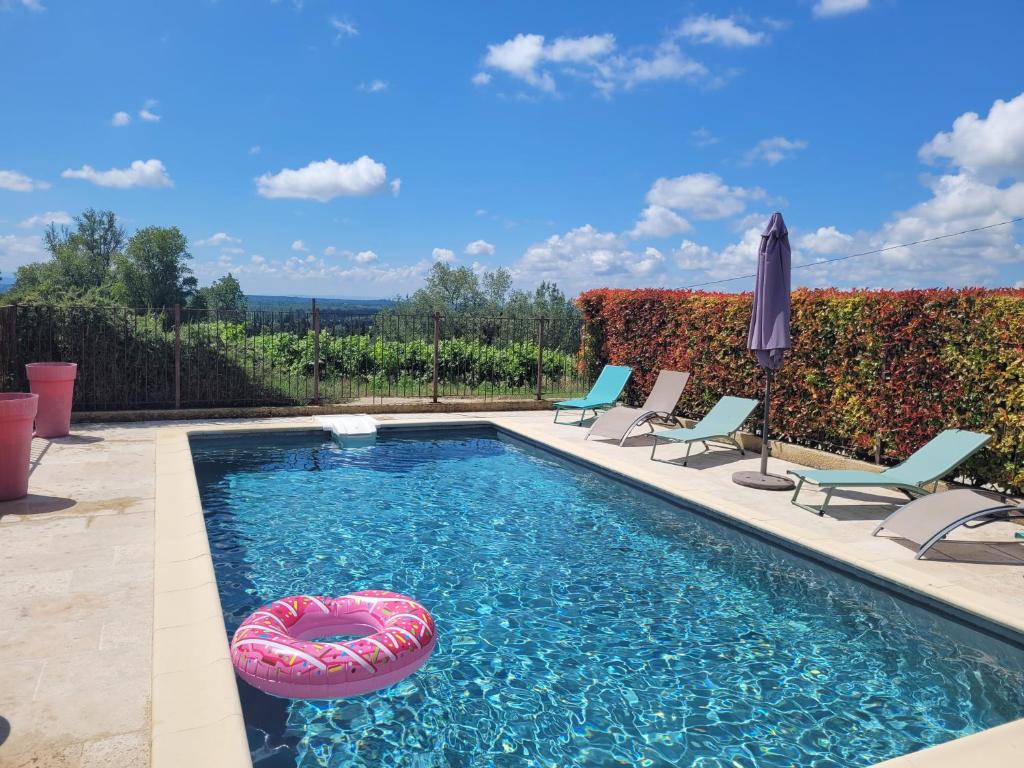 a swimming pool with chairs and a red heart in the water at Mas du Tilleul in Beaumes-de-Venise