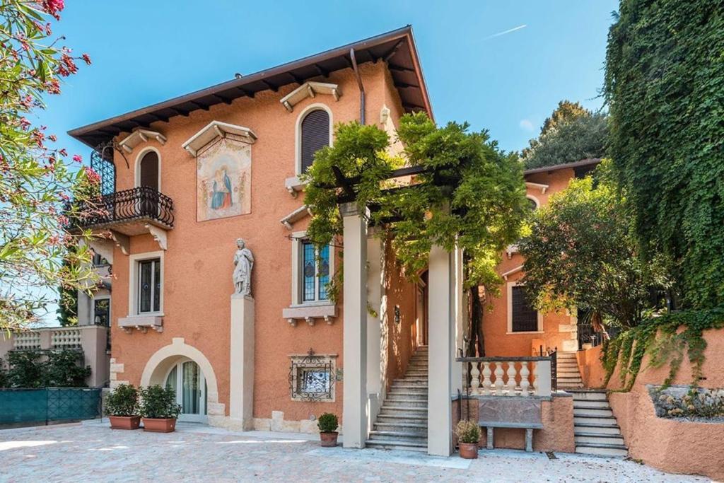 a house with a statue in front of it at Villa Natalia Luxury Rooms in Verona
