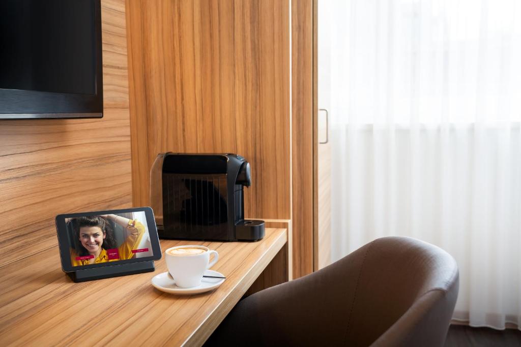 Una televisión o centro de entretenimiento en Leonardo Hotel Vienna Schönbrunn
