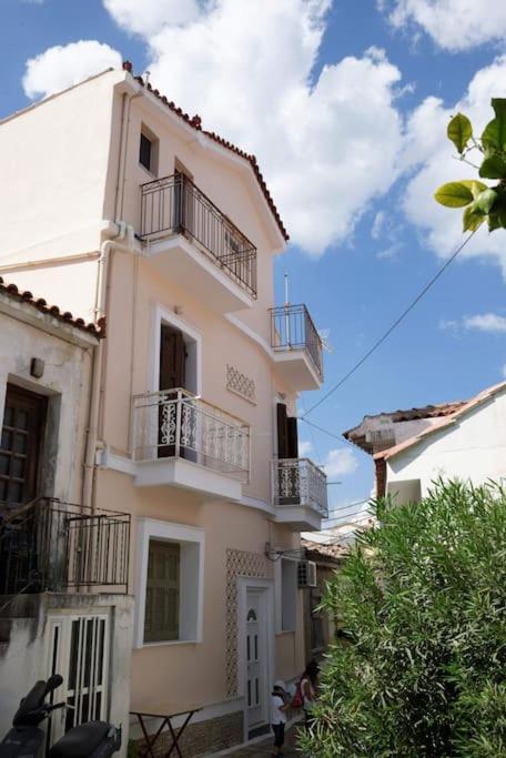 a tall white building with balconies on it at Hidden Treasure Unique Apartments Kokkari Samos in Samos