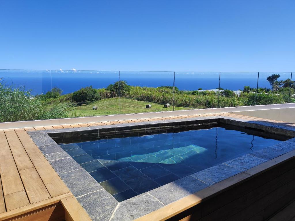 una piscina con vistas al océano en L'ApparT, meublé de tourisme 4 étoiles, piscine chauffée et vue mer imprenable, en Les Avirons