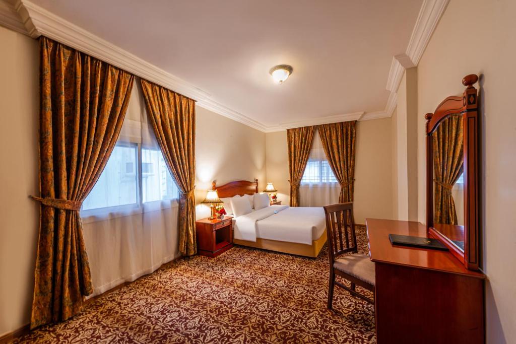 a hotel room with a bed and a desk and window at Boudl Palestine Jeddah in Jeddah