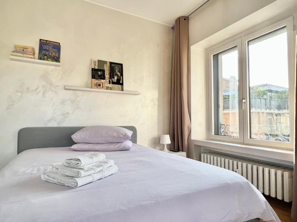 Un dormitorio con una cama blanca con toallas. en Tricolore Suite, en Milán