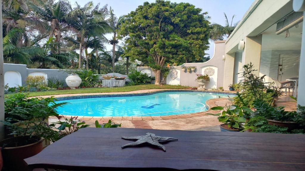 una estrella de mar sentada en una mesa junto a una piscina en Villa Roc Guesthouse - Solar Power en Ballito