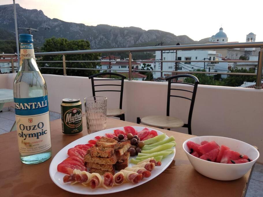 a plate of food on a table with a bottle of wine at Hidden Treasure kokkari Samos - Unique Apartments in Samos