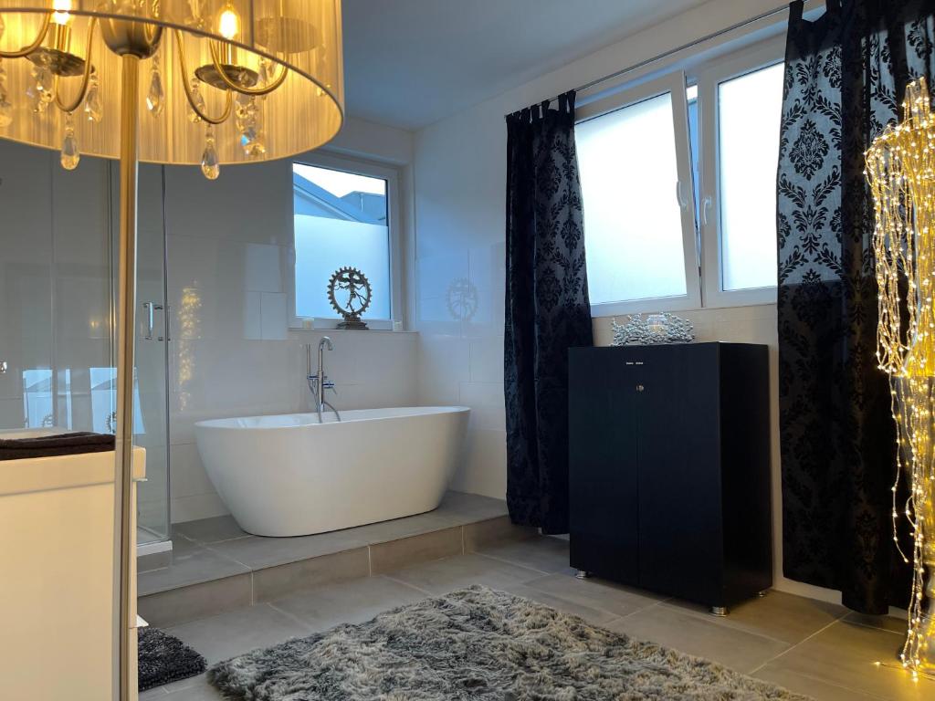 a bathroom with a tub and a large window at Casa li surii in Mönchengladbach