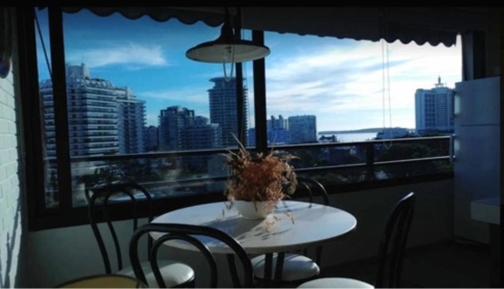 uma mesa e cadeiras numa varanda com vista para a cidade em Apartapunta em Punta del Este