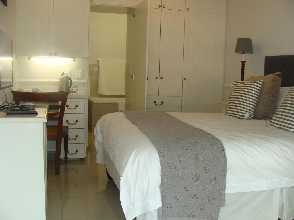 1 dormitorio con 2 camas, escritorio y cocina en Lonehill - Standard 2 Guest Studio Suite 1, en Sandton