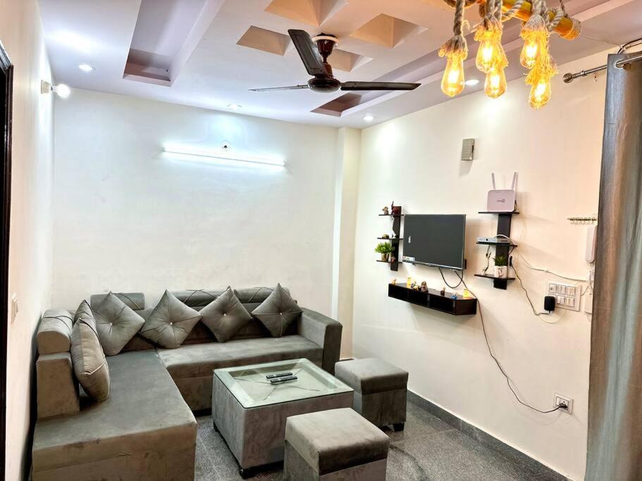 a living room with a couch and a tv at 2 Bhk apt near Manipal hospital by RDBL Hospitality Private limited in New Delhi