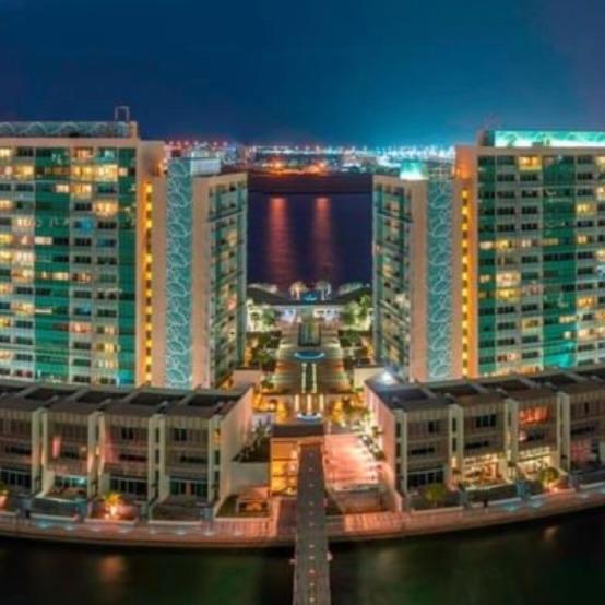 Una vista de una ciudad de noche con edificios. en Luxury private sea view room, en Abu Dabi