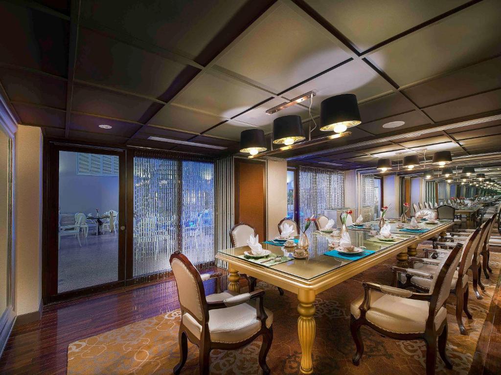 una lunga sala da pranzo con un lungo tavolo e sedie di Hotel de l'Opera Hanoi - MGallery a Hanoi