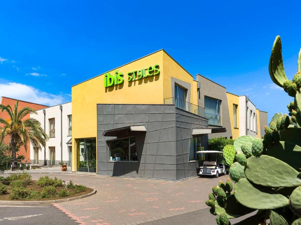 een gebouw met een bord aan de zijkant bij ibis Styles Catania Acireale in Acireale