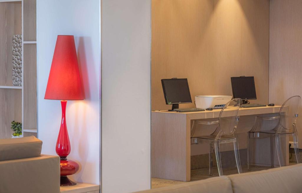 a living room with a desk with two computer monitors at Best Western Premier Hotel Prince de Galles in Menton