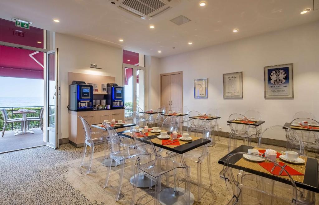 a dining room with a table and chairs in a room at Best Western Premier Hotel Prince de Galles in Menton