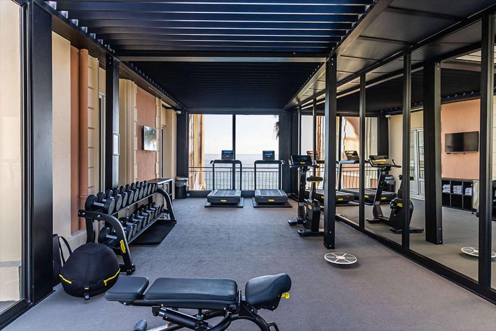 a gym with several treadmills and bikes in it at Best Western Premier Hotel Prince de Galles in Menton