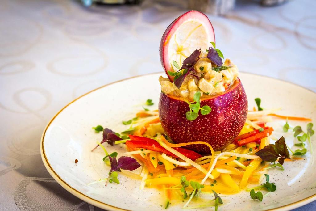 a plate of food with an apple on top of spaghetti at Best Western Premier Hotel Prince de Galles in Menton